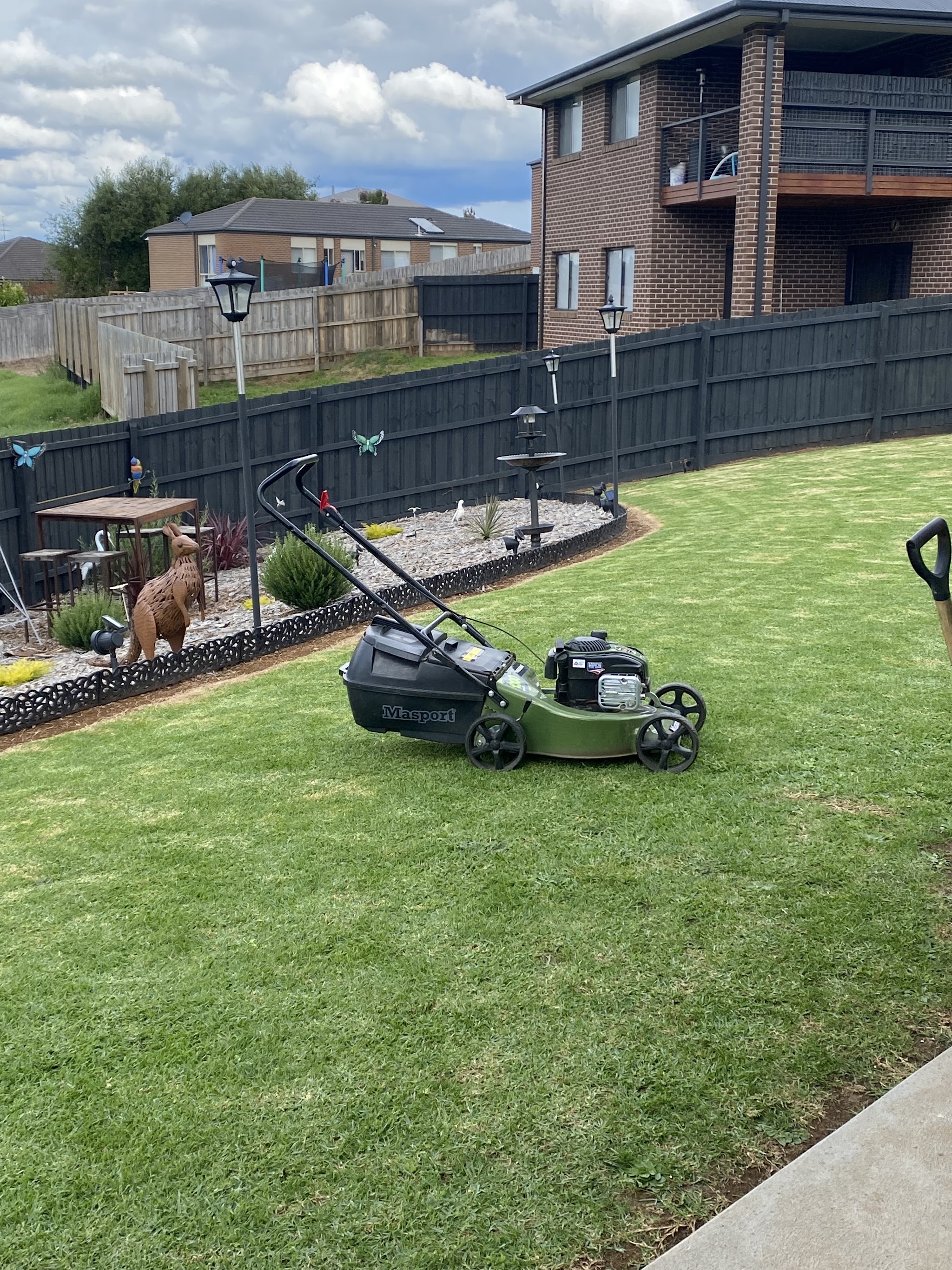 Freshly mown backyard lawn with a tidy mulched garden bed border in Warragul